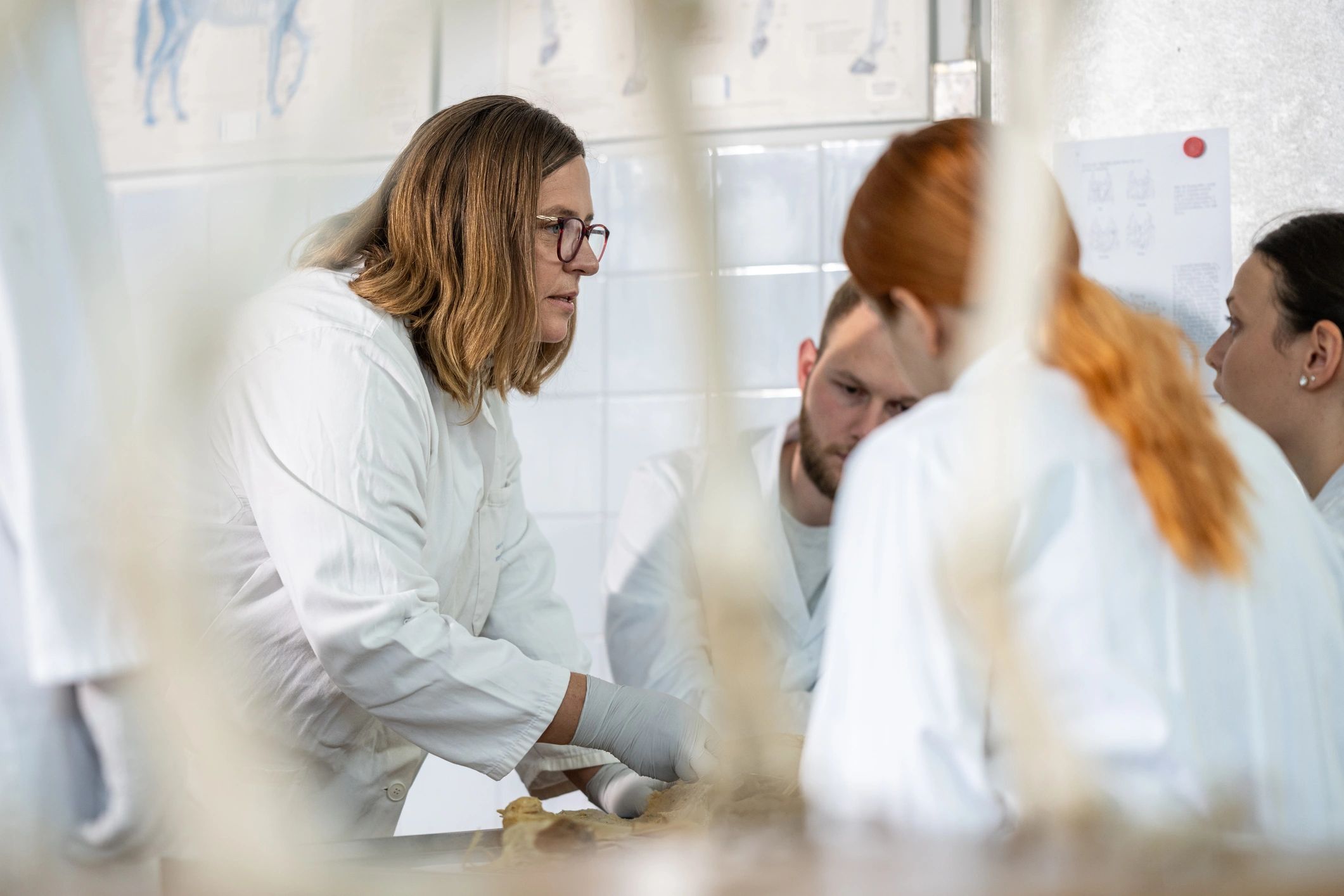 Professional in a lab coat presenting in a technical learning environment